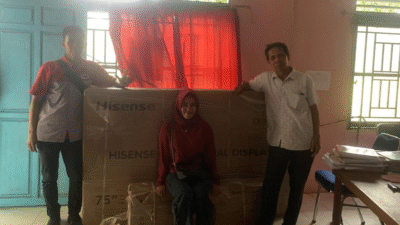 Kepala Sekolah SDN 14 Tolok Ogong bersama kurir ekspedisi berpose dengan bantuan papan tulis digital interaktif dari Presiden Prabowo yang baru tiba. (Dok. Ist)