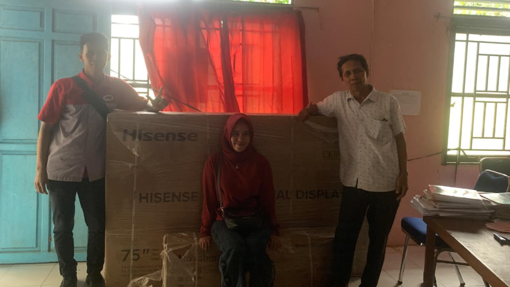 Kepala Sekolah SDN 14 Tolok Ogong bersama kurir ekspedisi berpose dengan bantuan papan tulis digital interaktif dari Presiden Prabowo yang baru tiba. (Dok. Ist)