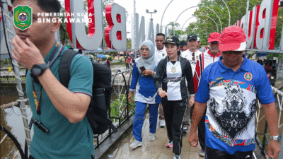 Wali Kota Singkawang Tjhai Chui Mie mengenakan pakaian olahraga berjalan bersama rombongan guru saat pembukaan HUT PGRI ke-80. (Dok. HO/Faktakalbar.id)