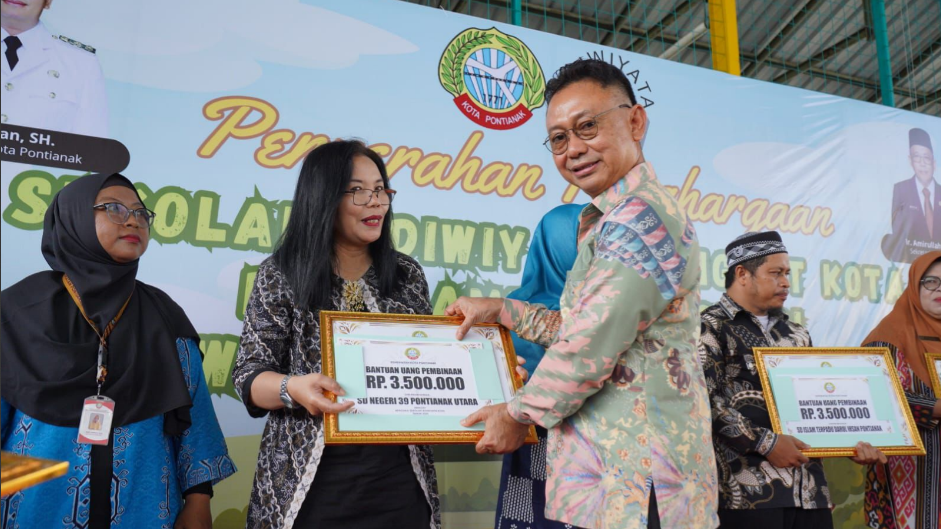 Wali Kota Pontianak Edi Rusdi Kamtono menyerahkan penghargaan Sekolah Adiwiyata dan uang pembinaan kepada Kepala SDN 39 Pontianak Utara. (Dok. HO/Faktakalbar.id)