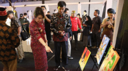 Wali Kota Singkawang Tjhai Chui Mie sedang mengamati lukisan burung enggang saat meninjau stan Pameran dan Pentas Seni Warisan Budaya. (Dok. Instagram/@prokopimsingkawang)