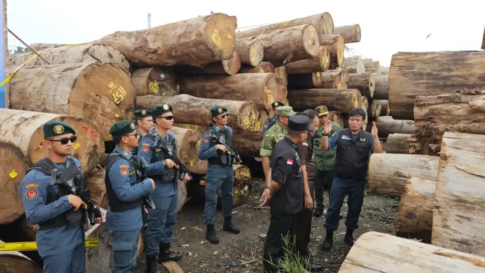 Petugas gabungan dari Kementerian Kehutanan dan Kejaksaan saat memeriksa barang bukti kayu sitaan terkait kasus dugaan illegal logging asal Mentawai di Pelabuhan Gresik, Jawa Timur, Minggu (1/12).