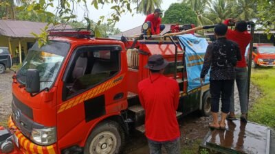 Petugas gabungan saat melakukan pengisian air bersih ke jeriken warga menggunakan truk tangki di lokasi terdampak banjir Kabupaten Padang Pariaman.