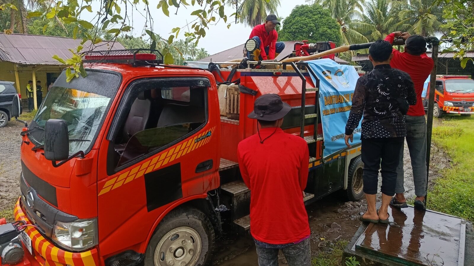 Petugas gabungan saat melakukan pengisian air bersih ke jeriken warga menggunakan truk tangki di lokasi terdampak banjir Kabupaten Padang Pariaman.
