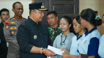 Bupati Ketapang, Alexander Wilyo (kiri), menyerahkan bantuan pendidikan secara simbolis kepada para pelajar di sela-sela kegiatan Safari Natal 2025, Minggu (12/12/2025). (Dok. HO.Faktakalbar.id)