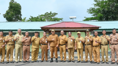 Barisan pejabat pemerintah daerah dan kepala desa mengenakan seragam dinas khaki berpose mengepalkan tangan sebagai simbol semangat kepemimpinan. (Dok. HO/Faktakalbar.id)