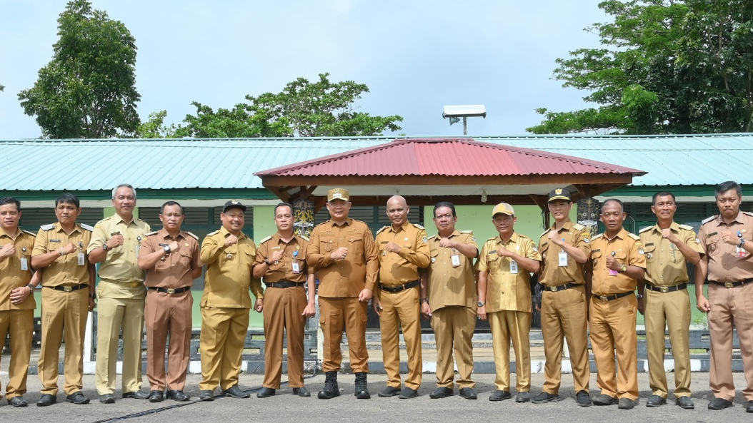 Barisan pejabat pemerintah daerah dan kepala desa mengenakan seragam dinas khaki berpose mengepalkan tangan sebagai simbol semangat kepemimpinan. (Dok. HO/Faktakalbar.id)