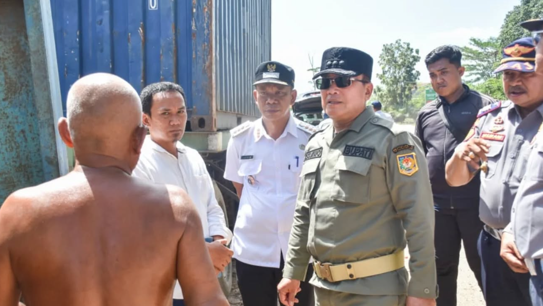 Bupati Sujiwo memakai kacamata hitam meninjau lokasi parkir liar truk kontainer di pinggir jalan Mayor Alianyang didampingi petugas Dishub. (Dok. HO/Faktakalbar.id)