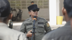 Bupati Sujiwo mengenakan seragam dinas lengkap, kacamata hitam, dan topi saat memimpin apel pagi dan berbicara menggunakan pelantang suara di markas Satpol PP. (Dok. HO/Faktakalbar.id)