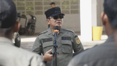 Bupati Sujiwo mengenakan seragam dinas lengkap, kacamata hitam, dan topi saat memimpin apel pagi dan berbicara menggunakan pelantang suara di markas Satpol PP. (Dok. HO/Faktakalbar.id)