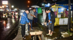 Bupati Kubu Raya Sujiwo menunjuk kondisi drainase saat sidak malam penataan kawasan di Jalan Perdamaian, Desa Pal IX. (Dok. Prokopim Kubu Raya)