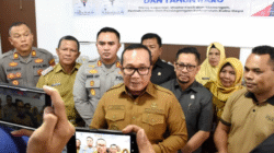 Bupati Kubu Raya Sujiwo mengenakan seragam dinas cokelat berbicara di depan wartawan didampingi pejabat terkait mengenai penanganan banjir rob. (Dok. HO/Faktakalbar.id)