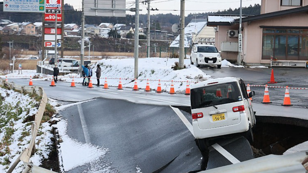 Mobil berwarna putih terperosok ke dalam lubang besar akibat jalan aspal yang runtuh setelah gempa bumi mengguncang Jepang saat musim dingin. (Dok. Ist)