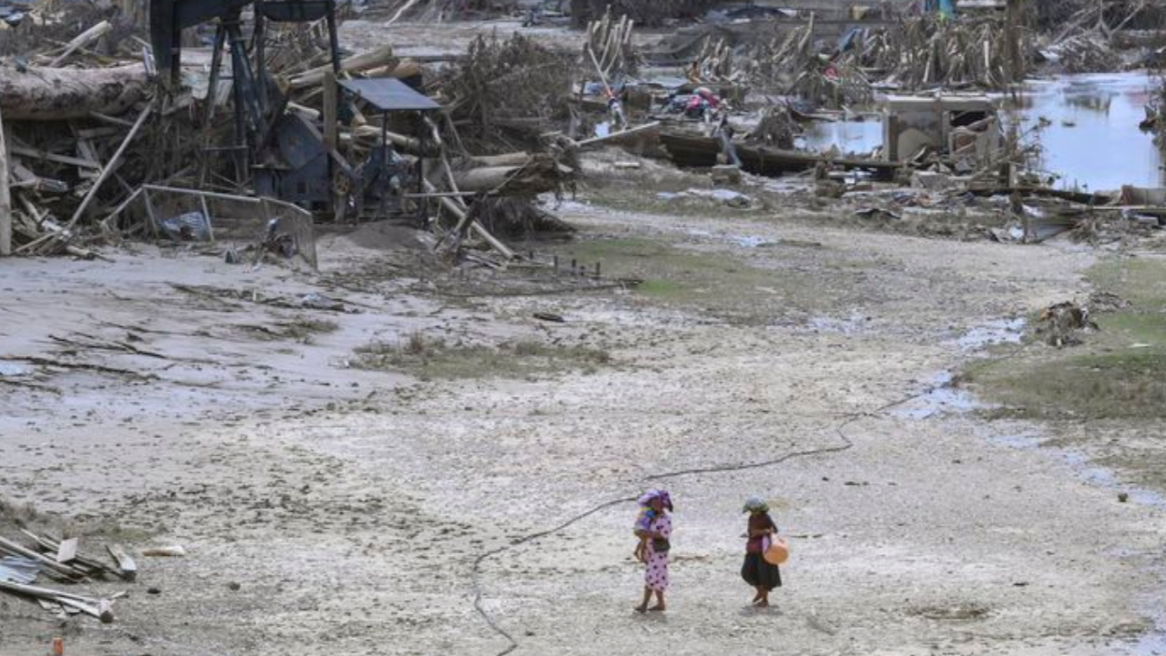 Kondisi porak-poranda pascabanjir bandang di wilayah Sumatra. Terlihat warga berjalan melintasi hamparan lumpur kering dan puing-puing kayu yang terseret arus, Kamis (25/12/2025). (Dok. HO/Faktakalbar.id)