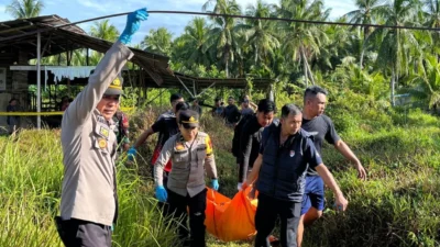 Personel kepolisian saat mengevakuasi kantong jenazah berisi jasad korban yang ditemukan di area bekas gudang batako di Mempawah Timur, Senin (22/12/2025).