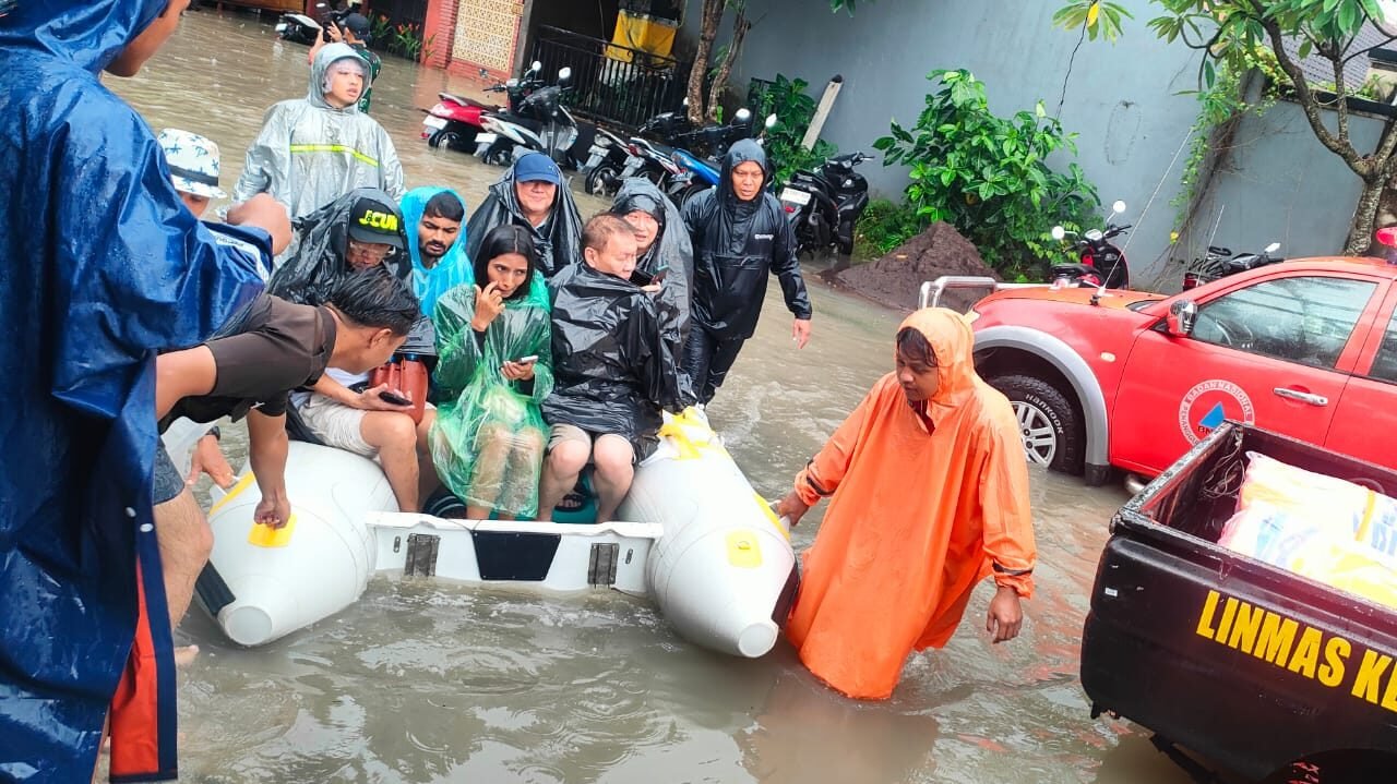 Petugas gabungan saat melakukan evakuasi warga dan penyisiran lokasi terdampak banjir di wilayah Denpasar, Bali, Minggu (14/12).