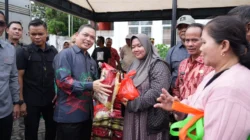 Gubernur Kalimantan Barat, Ria Norsan, menyerahkan secara simbolis paket sembako kepada warga saat pembukaan Gerakan Pangan Murah di Sintang, Sabtu (13/12/2025).