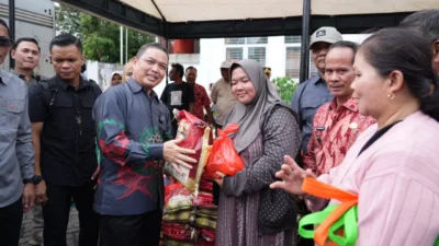 Gubernur Kalimantan Barat, Ria Norsan, menyerahkan secara simbolis paket sembako kepada warga saat pembukaan Gerakan Pangan Murah di Sintang, Sabtu (13/12/2025).