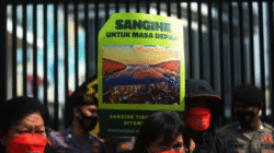 Massa aksi memegang poster bertuliskan "Sangihe Untuk Masa Depan" dan menolak kehadiran perusahaan tambang dengan latar belakang barikade polisi. (Dok. Ist)