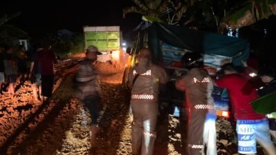 "Hujan deras buat Jalan Rantau Panjang, Kayong Utara berlumpur parah. Polisi dan warga gotong royong dorong kendaraan yang terjebak di malam hari."