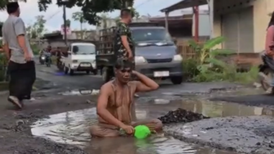 Aksi nekat Kepala Desa Bonder mandi lumpur di tengah jalan raya sebagai bentuk protes terhadap kerusakan infrastruktur jalan Penujak–Selong Belanak, Lombok Tengah, Jumat (19/12/2025). (Dok. Tiktok/street_journalist25)