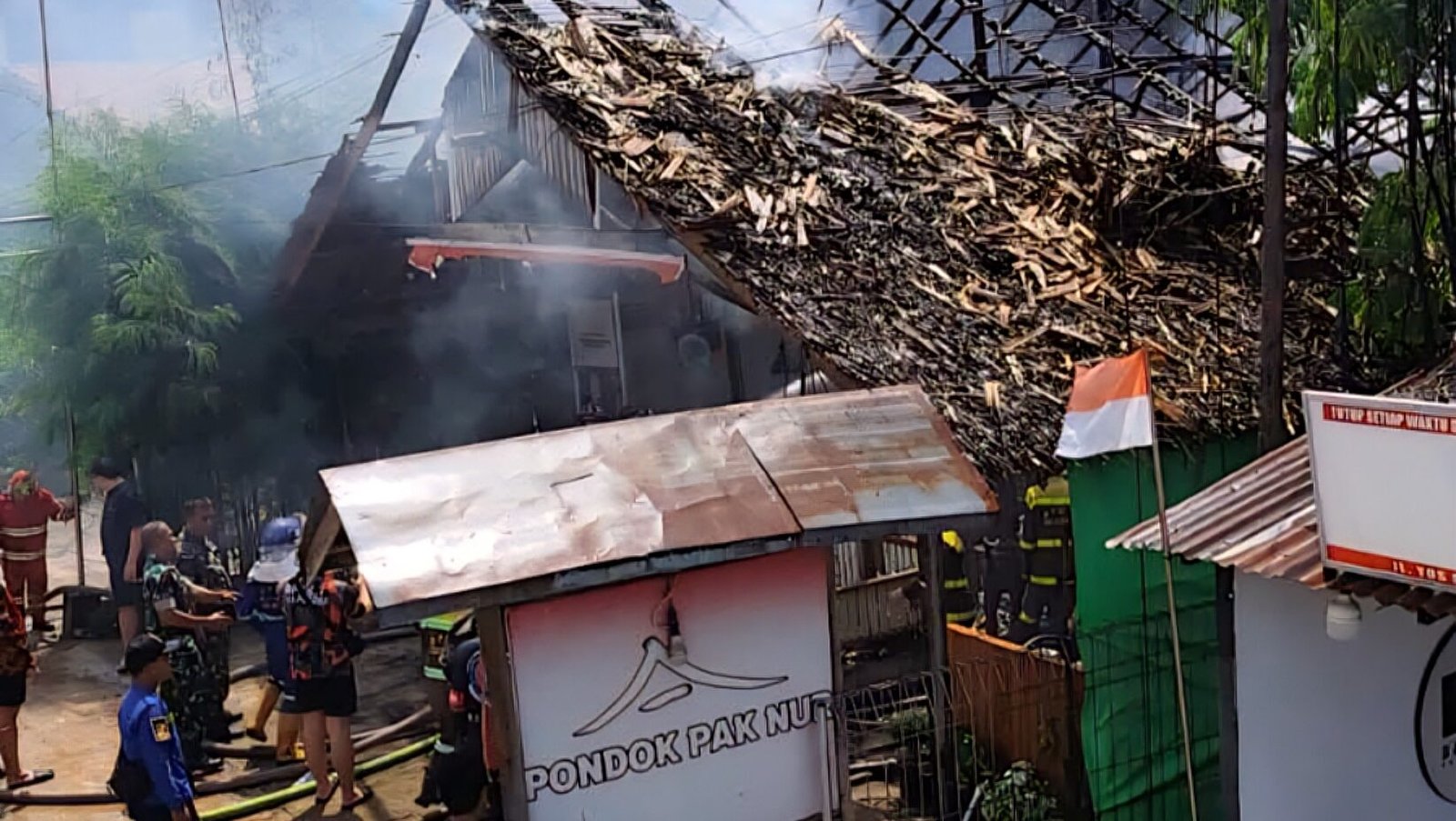 Kondisi bangunan Pondok Makan Pak Nur di Singkawang yang hangus terbakar dengan kepulan asap yang masih tersisa usai api berhasil dipadamkan petugas, Selasa (9/12/2025) siang.