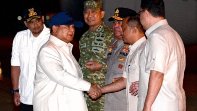 Presiden Prabowo mengenakan kemeja putih dan topi biru bersalaman dengan petinggi TNI dan Polri saat tiba di bandara pada malam hari. (Dok. HO/Faktakalbar.id)