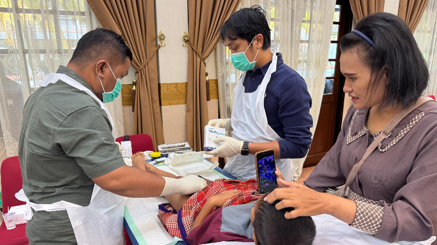 Petugas medis dengan alat pelindung diri lengkap melakukan tindakan sunat kepada seorang anak laki-laki yang didampingi ibunya. (Dok. HO/Faktakalbar.id)