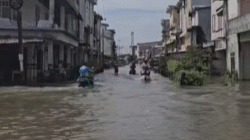 Pengendara sepeda motor menerobos genangan air pasang laut yang merendam ruas jalan dan permukiman di Kabupaten Ketapang, Sabtu (6/12/2025).