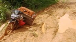 Sebuah sepeda motor yang membawa muatan barang tampak kesulitan melintasi Jalan Inggar, Kecamatan Kayan Hilir, Kabupaten Sintang, yang kondisinya rusak parah dan dipenuhi lumpur tebal.