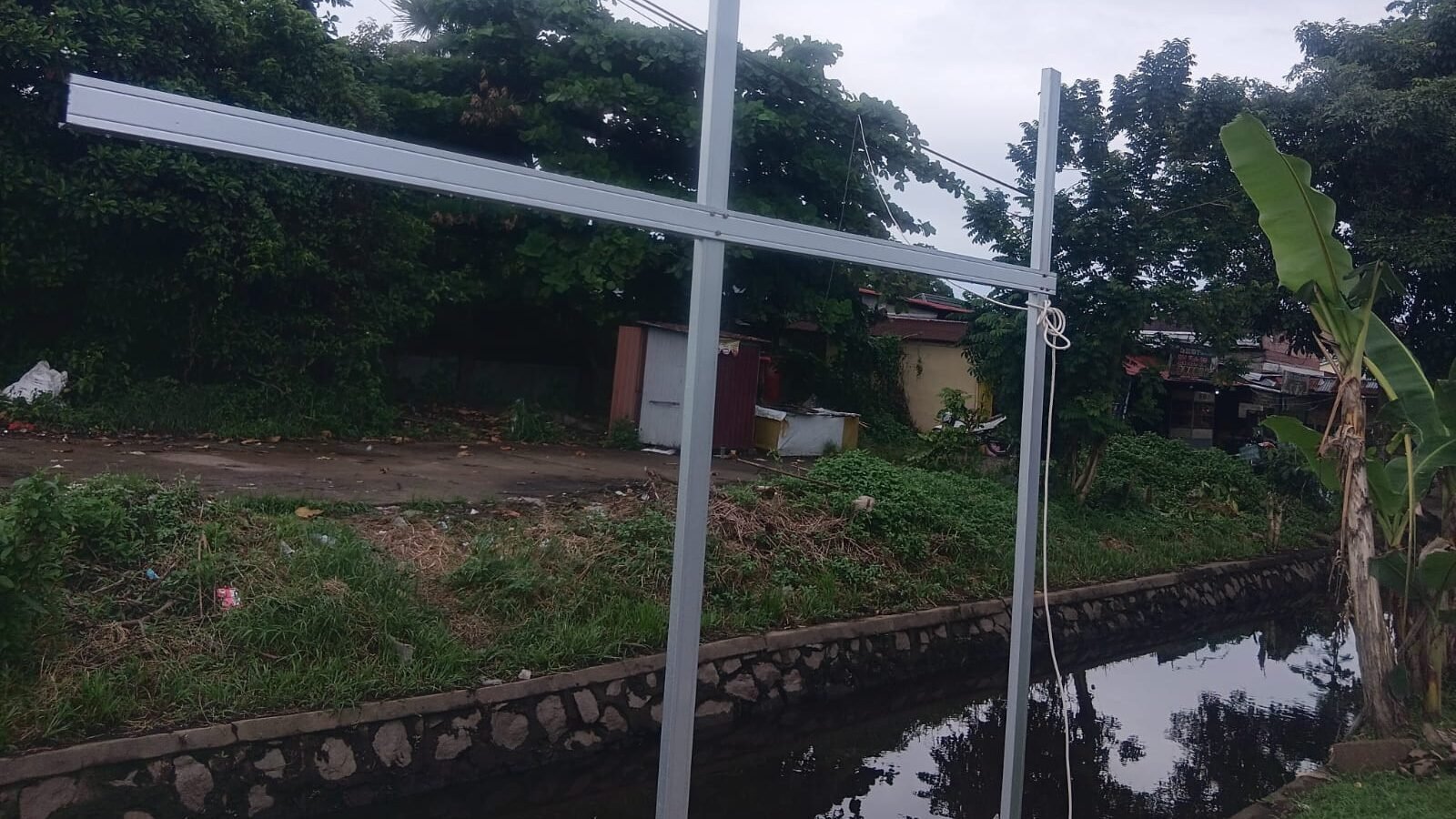 Kondisi terkini salah satu titik ruas jalan paralel di kawasan Jalan Ampera, Pontianak, yang pengerjaannya terhenti dan kini ditumbuhi semak belukar.