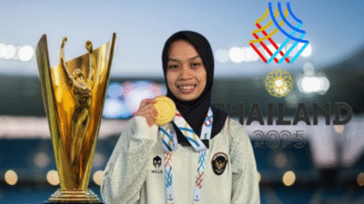 Luluk Diana Tri Wijayana tersenyum memegang medali emas angkat besi dengan latar belakang logo SEA Games Thailand 2025. (Dok. Ist)