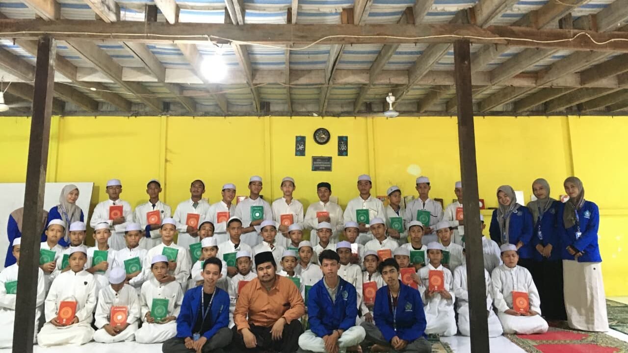 Mahasiswa KKL STAI Al-Haudl Ketapang menyerahkan bantuan wakaf Al-Qur'an kepada pengasuh Pondok Pesantren Sirajul Mukminin Az-Zakiyah di Desa Pesaguan Kanan, Jumat (19/12/2025).