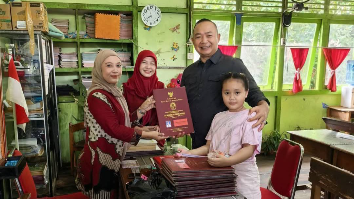Bupati Ketapang, Alexander Wilyo, tersenyum sumringah saat mendampingi putrinya, Amethya Rashi Gloria, menerima buku rapor di SD Negeri 07 Delta Pawan. (Dok. Facebook/Alexander Wilyo)
