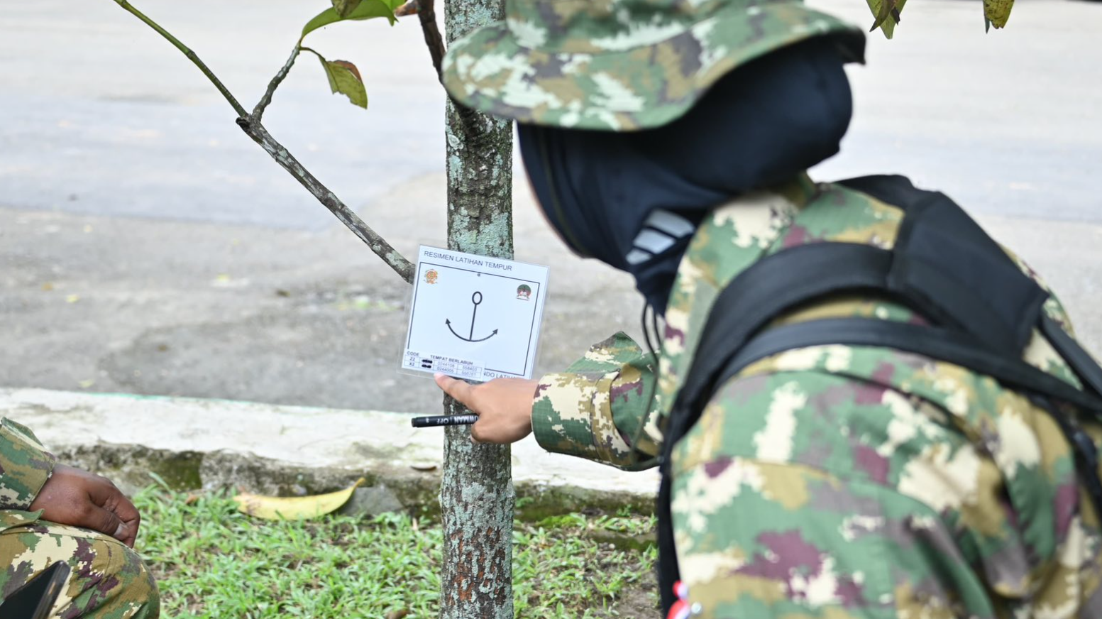 Seorang peserta pelatihan sedang melakukan pencocokan koordinat peta dengan tanda medan (waypoint) yang terpasang di pohon saat praktik navigasi darat di Menlatpur Kostrad Sanggabuana, Karawang, Rabu (17/12/2025). (Dok. HO/Faktakalbar.id)