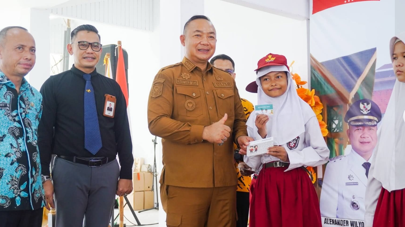 Bupati Ketapang, Alexander Wilyo (tengah), menyerahkan secara simbolis Kartu Ketapang Pintar kepada perwakilan pelajar di Pendopo Bupati, Senin (22/12/2025). (Dok. HO/Faktakalbar.id)
