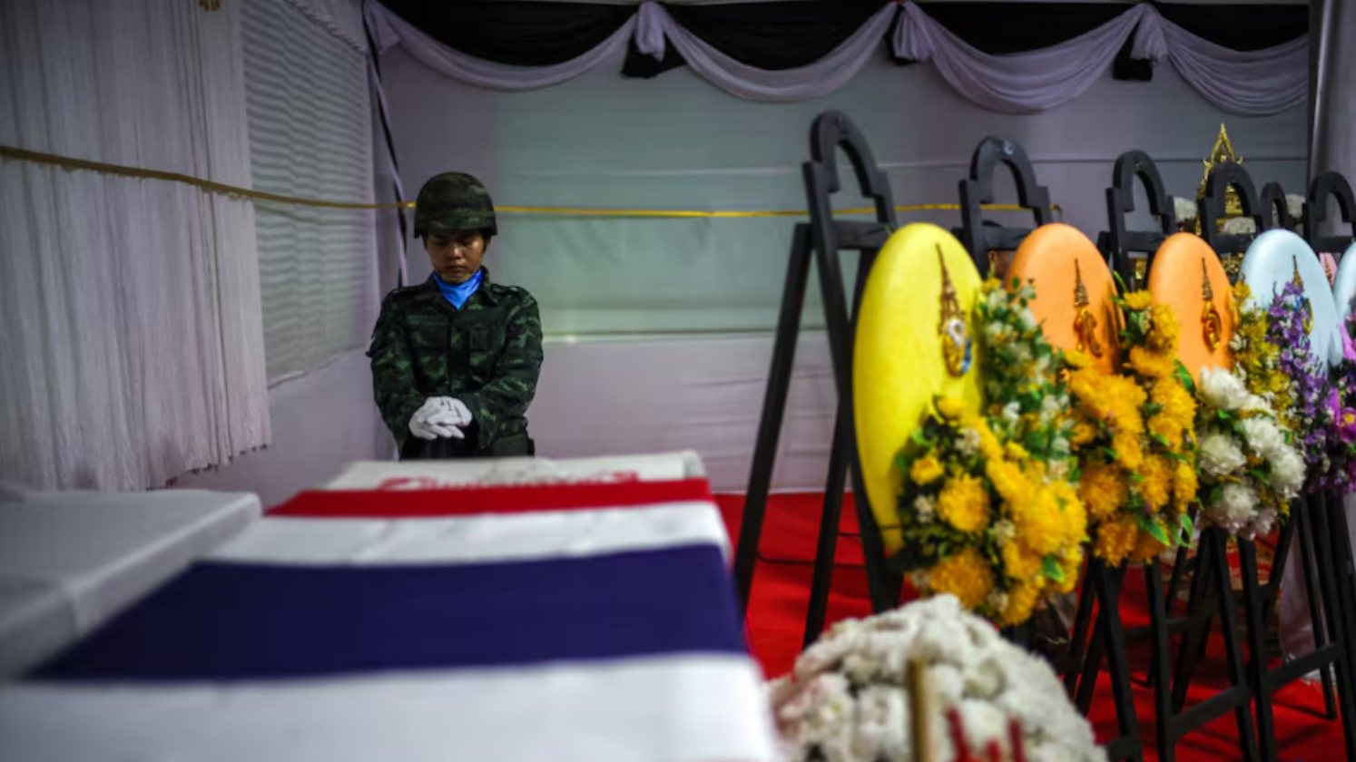 Seorang tentara memberikan penghormatan terakhir di samping peti jenazah Sersan Mayor Ananda Udon (39), prajurit Thailand yang gugur dalam bentrokan perbatasan dengan Kamboja, saat upacara pemakaman di sebuah kuil di Provinsi Si Sa Ket, Thailand. (Dok. REUTERS/Athit Perawongmetha)