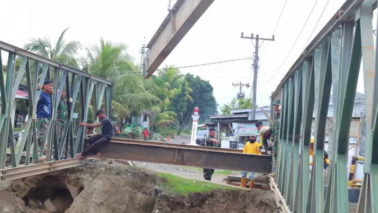 Personel TNI dari Yonzipur 11/DW bahu-membahu bersama petugas Dinas PU merakit kerangka Jembatan Super Compact 200 di Desa Paya Bakung, Deli Serdang, Rabu (17/12/2025). (Dok. Dispen TNI)