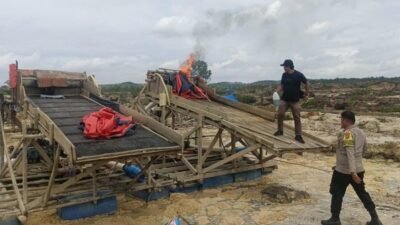 Personel gabungan TNI-Polri saat melakukan pemusnahan dengan cara membakar belasan rakit dompeng dalam operasi penertiban PETI di Sungai Tanalo, Kecamatan Kuantan Mudik, Kamis (11/12/2025).