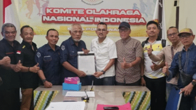 Dedet Gunawan (baju putih) menyerahkan berkas pendaftaran sebagai bakal calon Ketua Umum KONI Kota Pontianak kepada Ketua TPP, Tugio, disaksikan oleh pendukung dan pengurus cabang olahraga, Selasa (16/12/2025). (Dok. HO/Faktakalbar.id)