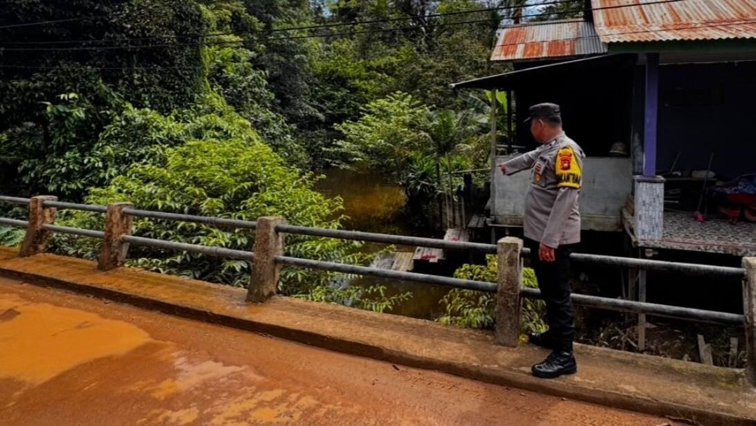 Personel Polsek Toba, saat melakukan pengecekan debit air di Sungai Dawak, Kecamatan Toba, Kabupaten Sanggau, Sabtu (13/12/2025).