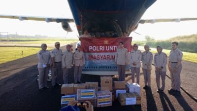 Personel Polri bersama relawan saat memuat paket bantuan logistik ke dalam pesawat CN 295 di Lanud Pondok Cabe untuk diterbangkan ke lokasi bencana di Sumatera.