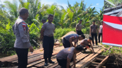 Beberapa personel Satbrimob Polda Kalbar memperbaiki Jembatan Desa Sukabaru Ketapang. (Dok. HO/Faktakalbar.id)