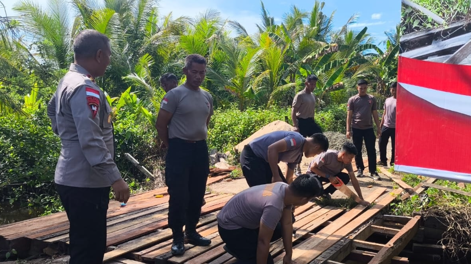 Beberapa personel Satbrimob Polda Kalbar memperbaiki Jembatan Desa Sukabaru Ketapang. (Dok. HO/Faktakalbar.id)