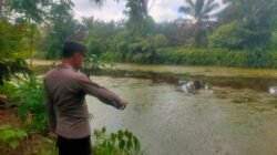 Personel Polres Kubu Raya saat melakukan pengecekan debit air di salah satu parit besar guna mengantisipasi luapan air akibat curah hujan tinggi, Jumat (5/12/2025).