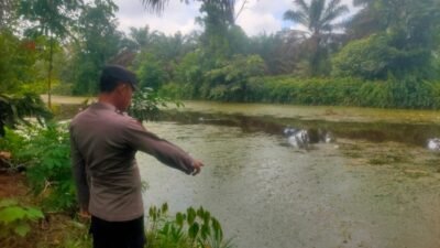 Personel Polres Kubu Raya saat melakukan pengecekan debit air di salah satu parit besar guna mengantisipasi luapan air akibat curah hujan tinggi, Jumat (5/12/2025).