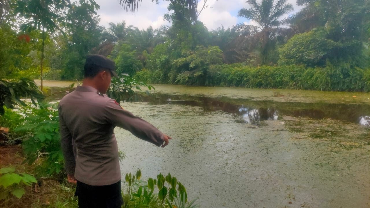 Personel Polres Kubu Raya saat melakukan pengecekan debit air di salah satu parit besar guna mengantisipasi luapan air akibat curah hujan tinggi, Jumat (5/12/2025).