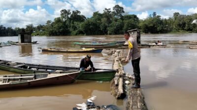 Personel Polres Melawi saat melakukan pemantauan debit air di sungai untuk mengantisipasi potensi banjir akibat curah hujan yang meningkat, Kamis (4/12).