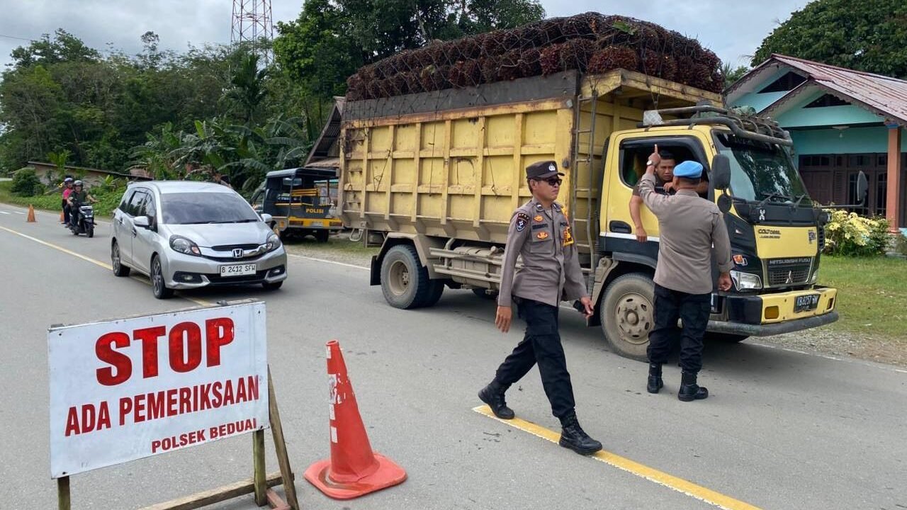 Personel Polsek Beduai saat melakukan pemeriksaan kelengkapan surat dan barang bawaan pengendara dalam razia cipta kondisi di depan Mapolsek, Jumat (12/12/2025).