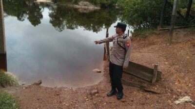 Personel Polsek Jangkang saat melakukan pengecekan debit air Sungai Mengkiang dan memberikan imbauan kepada warga dalam kegiatan patroli antisipasi bencana. Foto: HO/Faktakalbar.id